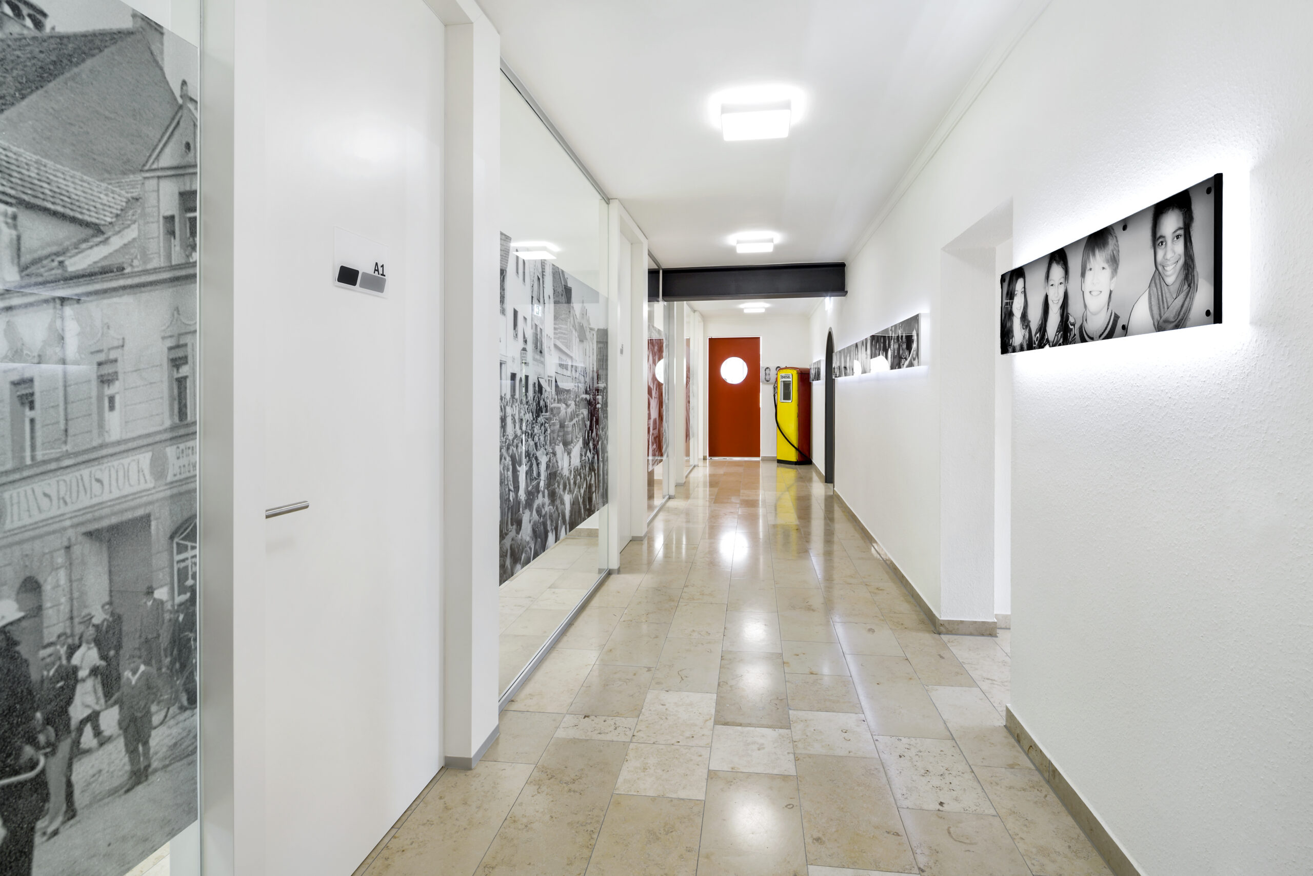 Blick in den langen Flur mit großformatigen Schwarz-Weiß-Fotografien.