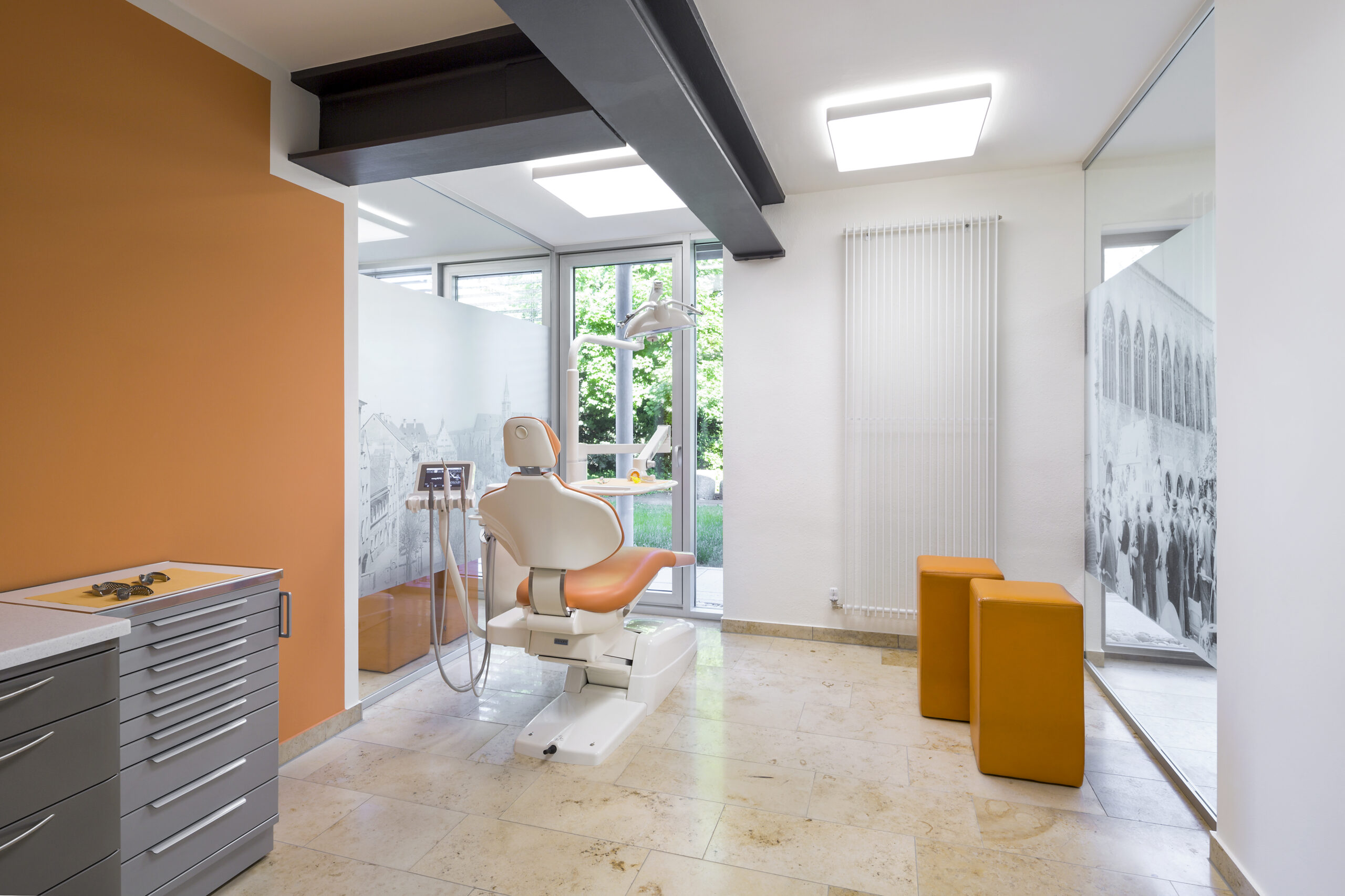 Blick in eines der Behandlungszimmer. Heller Raum mit Blick in den Garten.